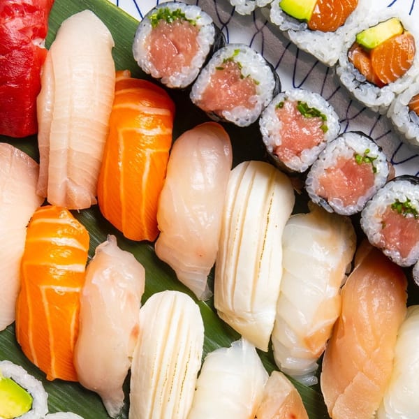 Assortment of Kombu Sushi rolls and nigiri with various fish, including tuna, salmon, and white fish.